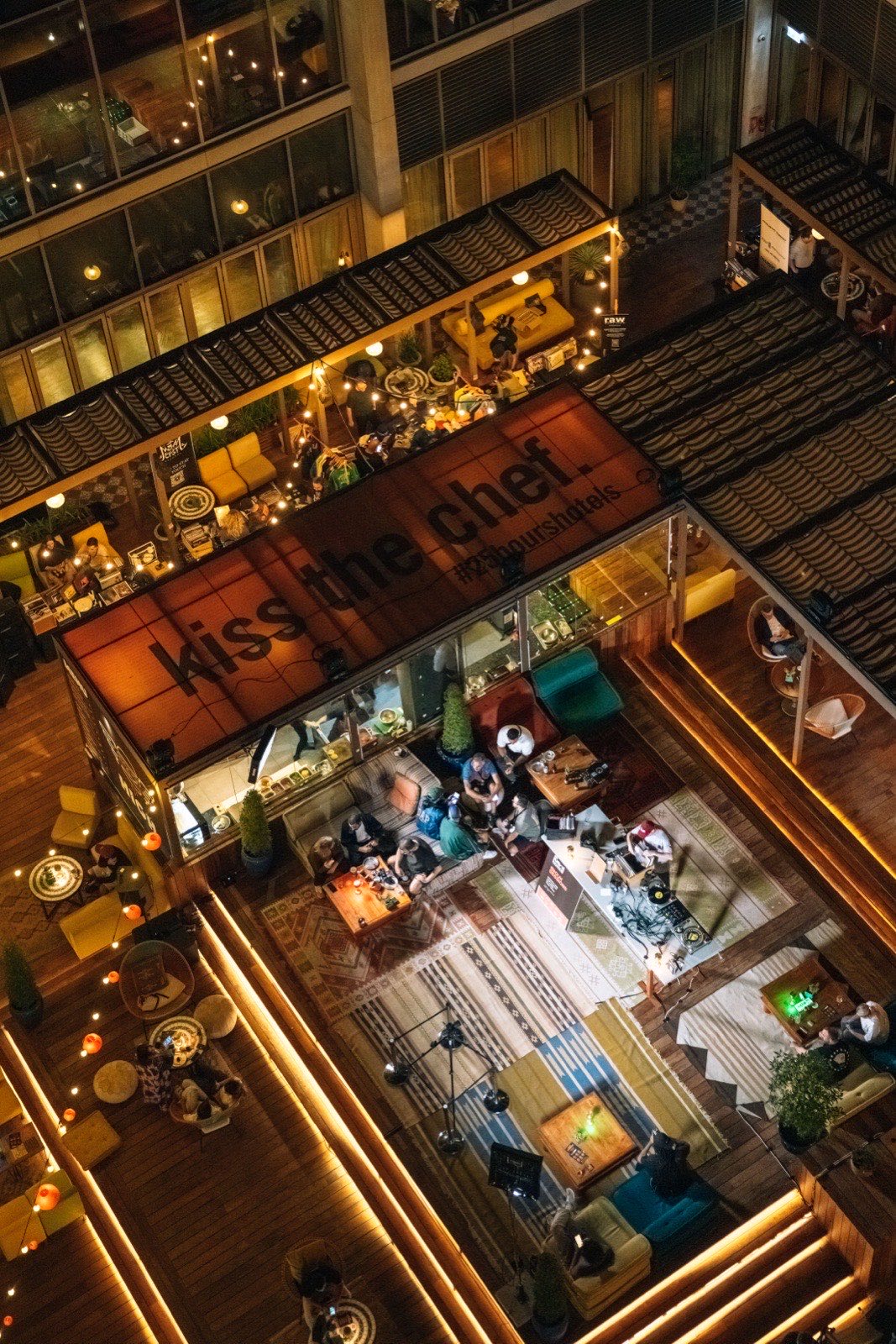 The festival seen from above, with a Kiss the Chef sign and stalls below.