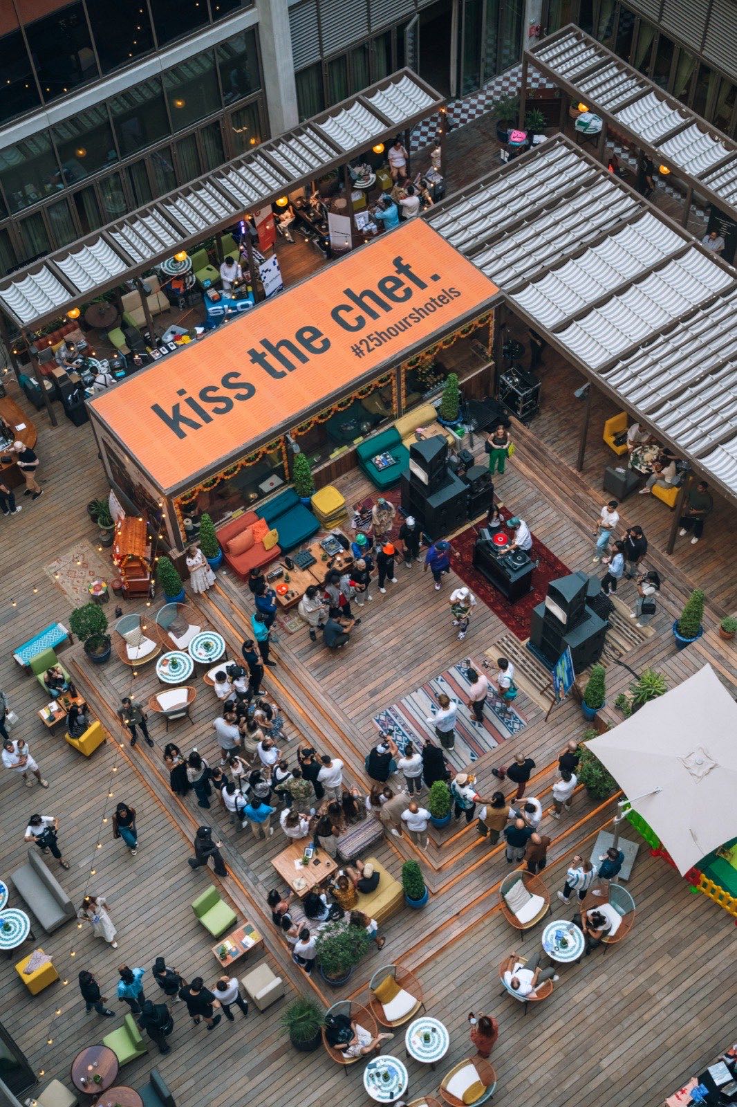 The festival seen from above: a Kiss the Chef sign, stalls and crowds on the terrace.