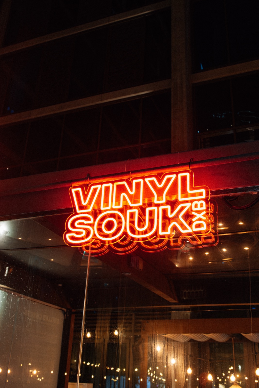 A red Vinyl Souk neon sign glowing above the bar.