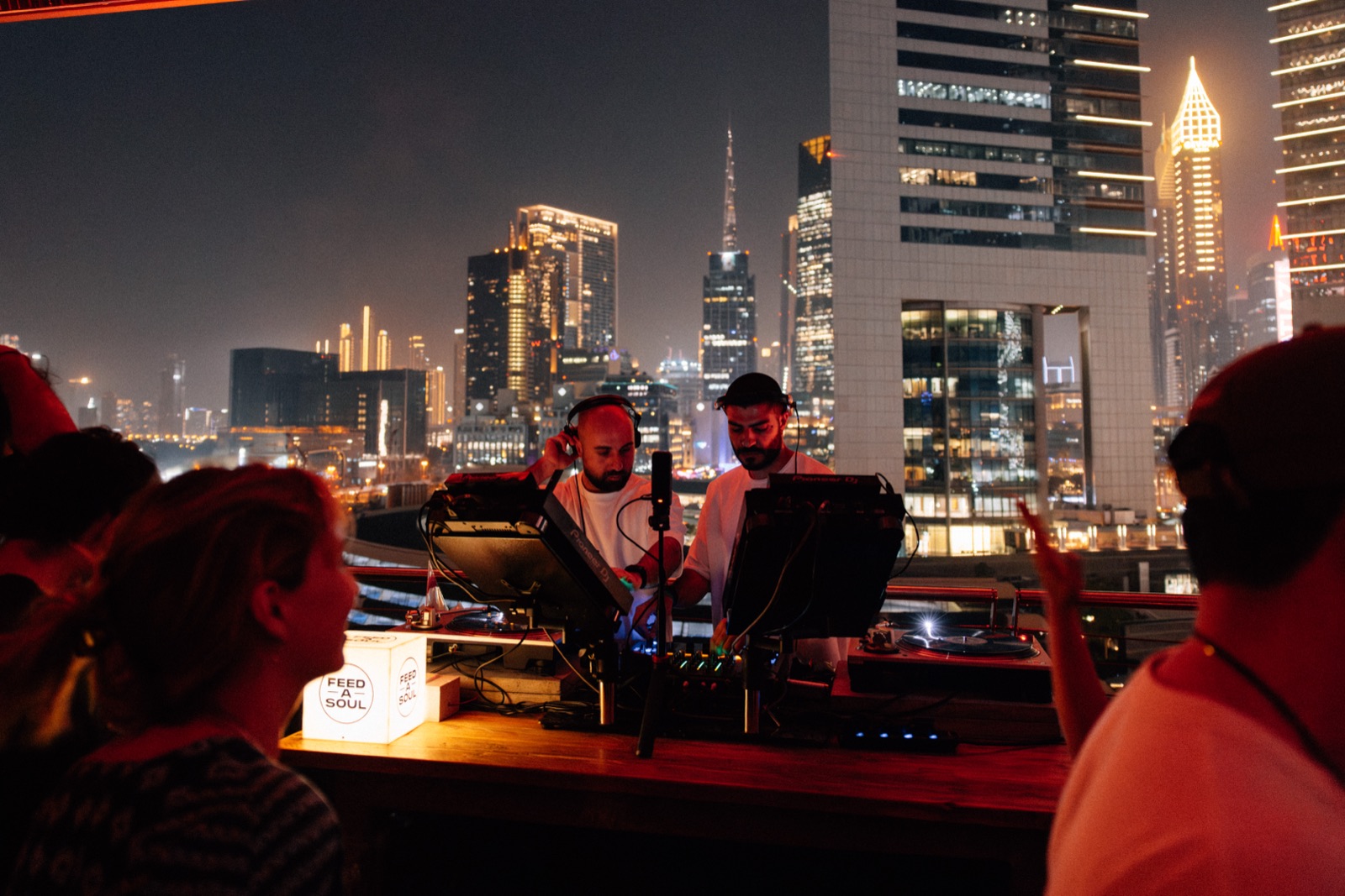 The decks on the terrace at night, with Dubai’s towers lit up behind.