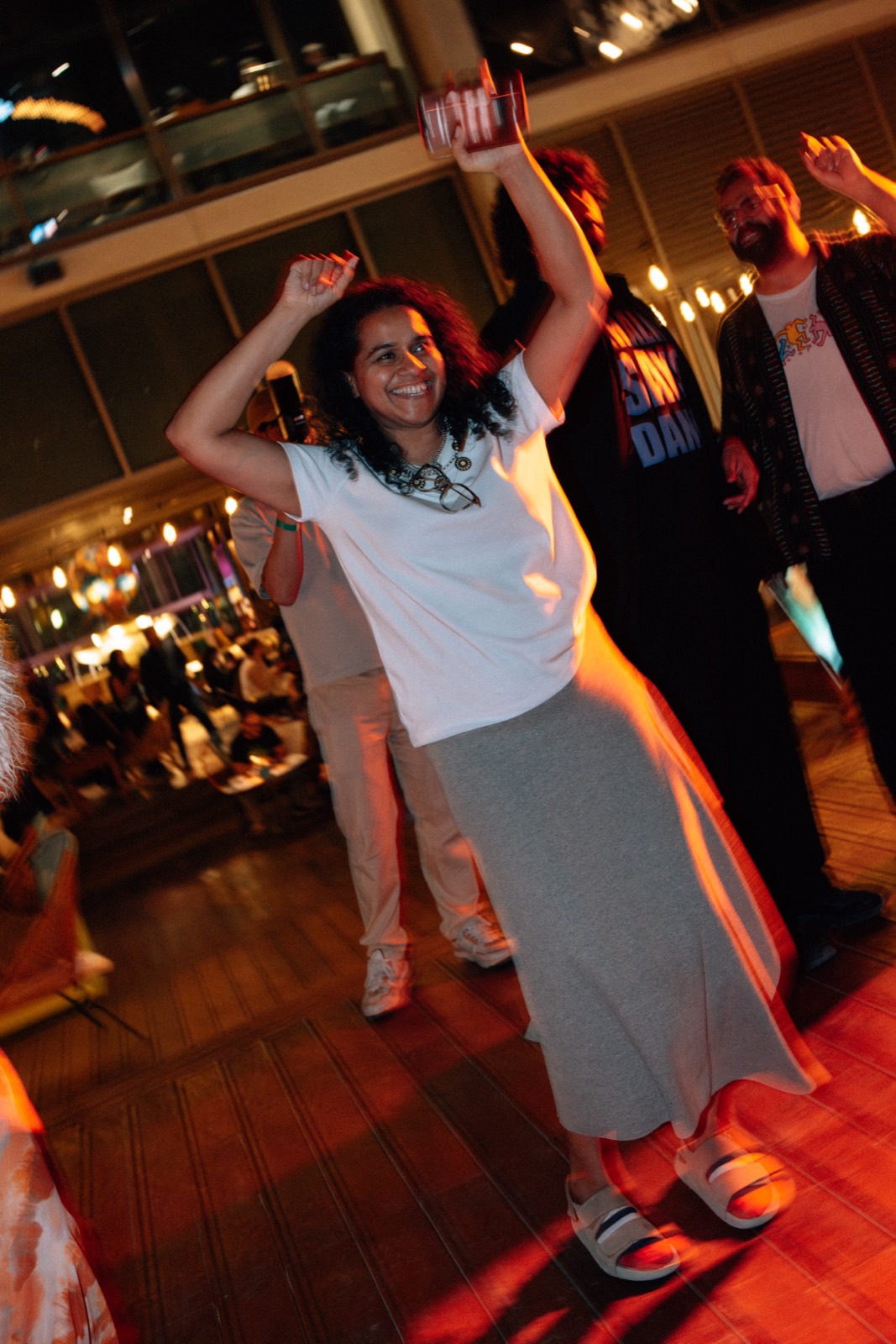 Someone dancing with their arms raised as the room moves around them.