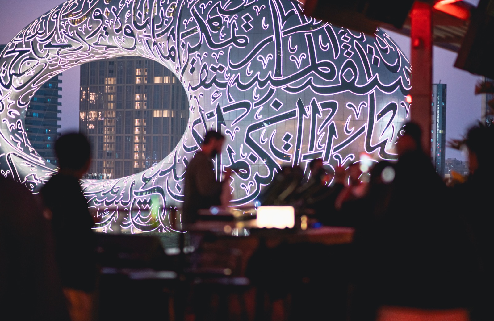 The decks set up in front of the Museum of the Future, its calligraphy lit at dusk.