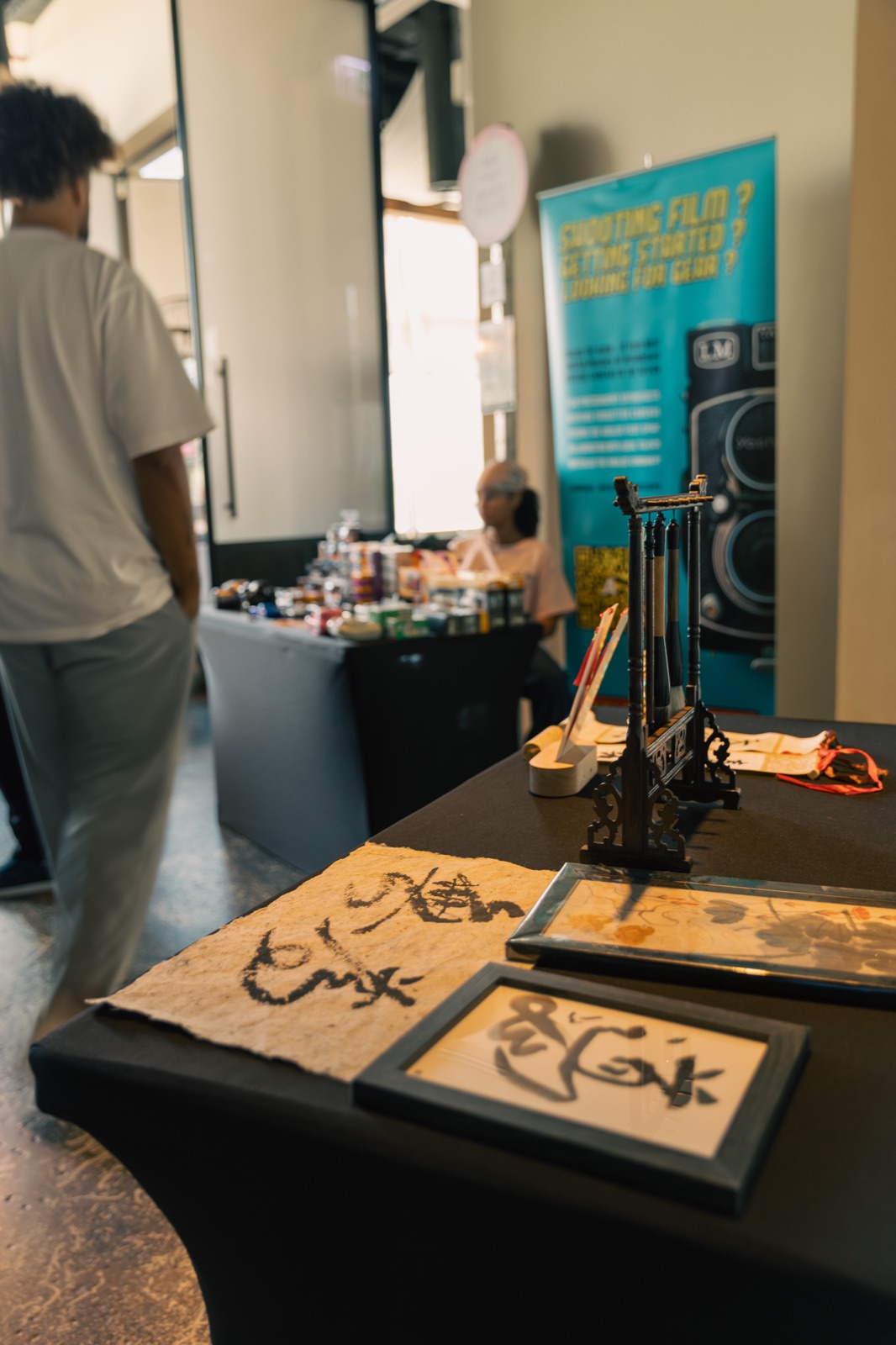 Framed Arabic calligraphy and a drawing machine on a table.