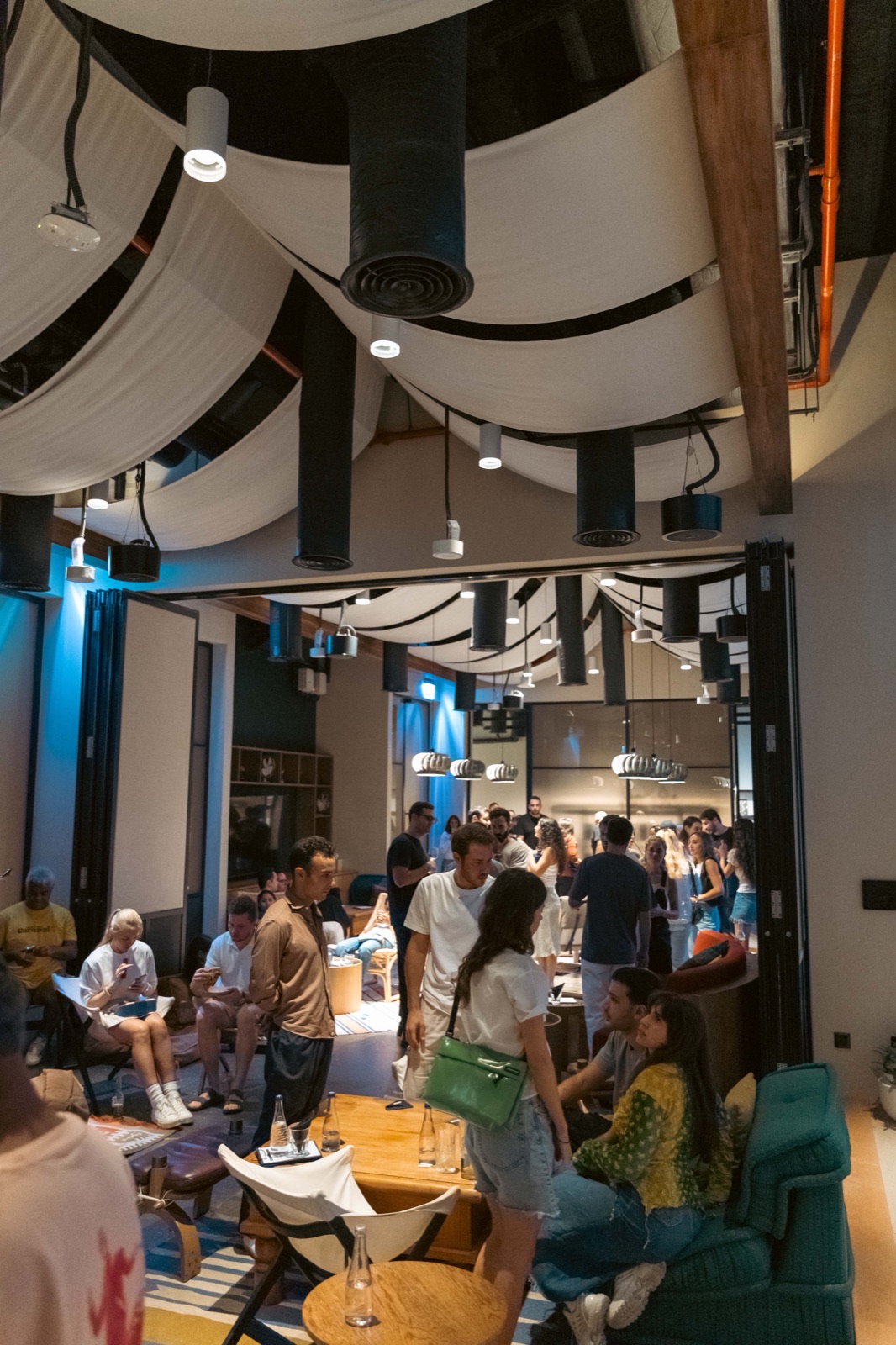 A crowd in a large room with a draped ceiling.