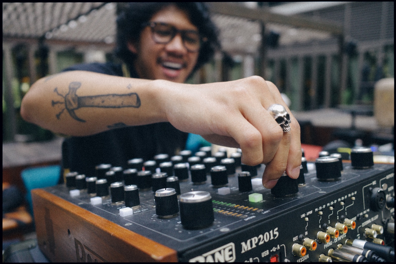 A hand turning the knobs of a rotary mixer.