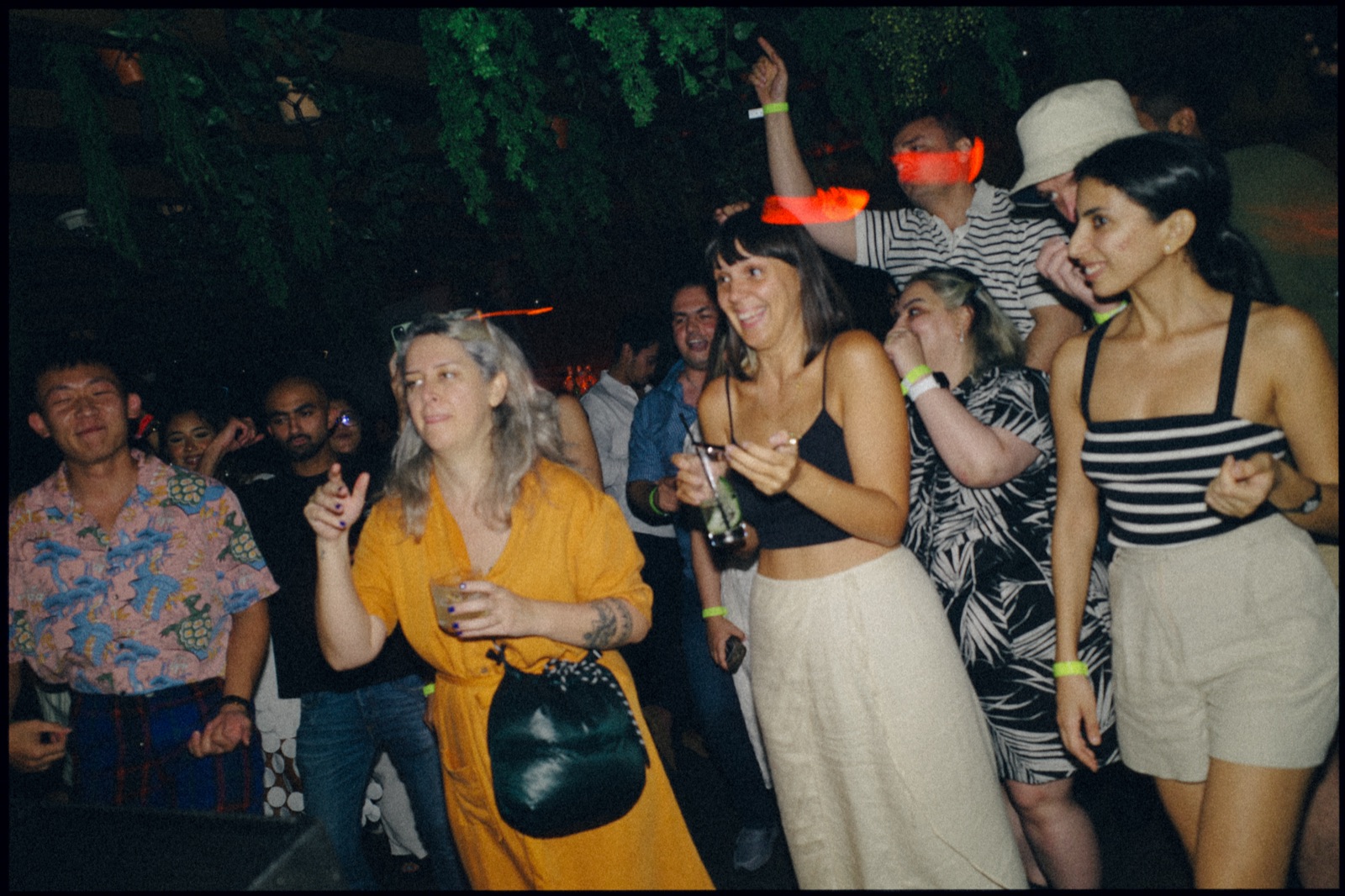 A crowd dancing and laughing at night.