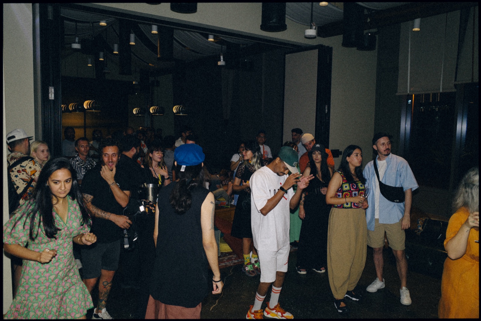 A crowd dancing in a dimly lit room.