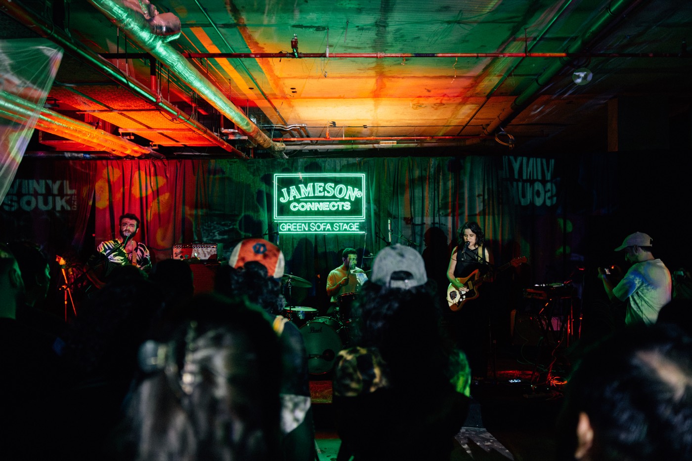 A band playing on the Jameson Connects Green Sofa Stage, with Vinyl Souk banners behind them.